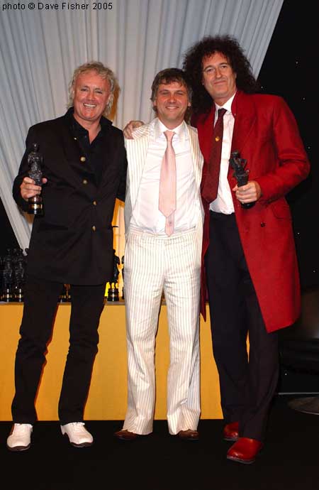 "Brian and Roger receiving their Outstanding Song Collection award from Guy Chambers. Ivor Novello Awards, London, 26 May 2005 Photo by kind permission DAVE FISHER to BrianMay.com