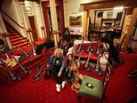 Brian and Arielle seated on carpet among guitars
