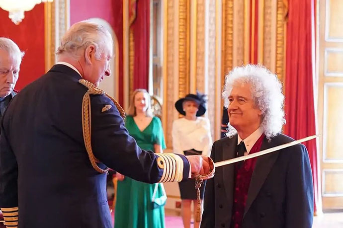 Receiging knighthood from King Charles