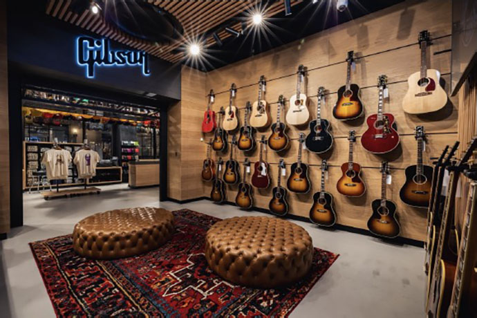 Gibson Garage London main room with revolving guitars and exclusive apparel. Gibson Garage London Acoustic room.